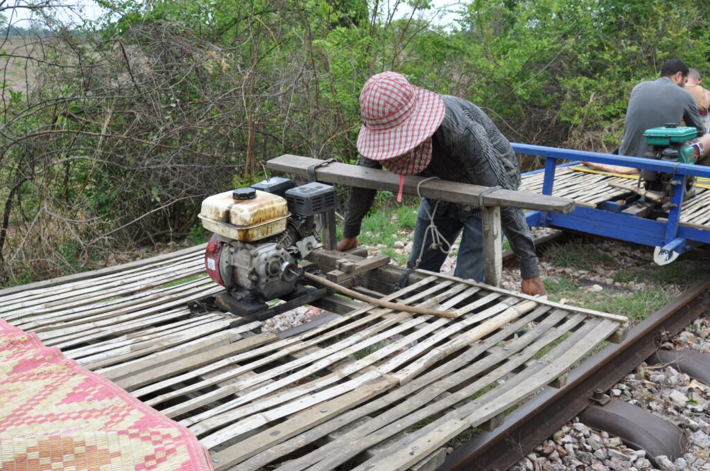 Reassembling a bamboo train on the track, Battambang, Cambodia