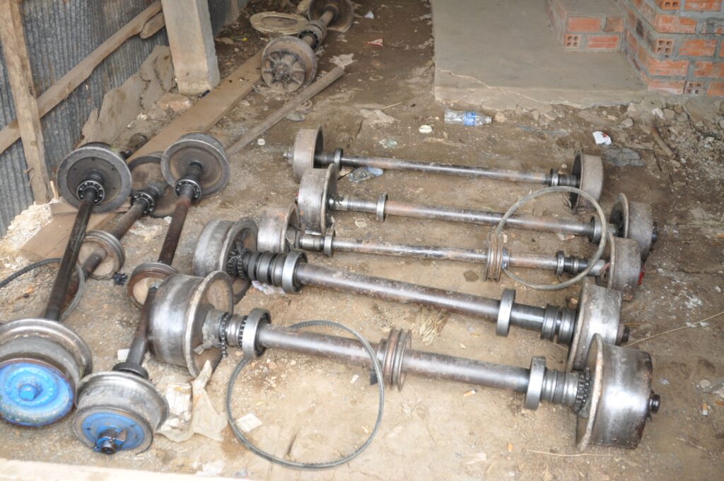 Spare bamboo train wheels and axles in a workshop, Battambang, Cambodia