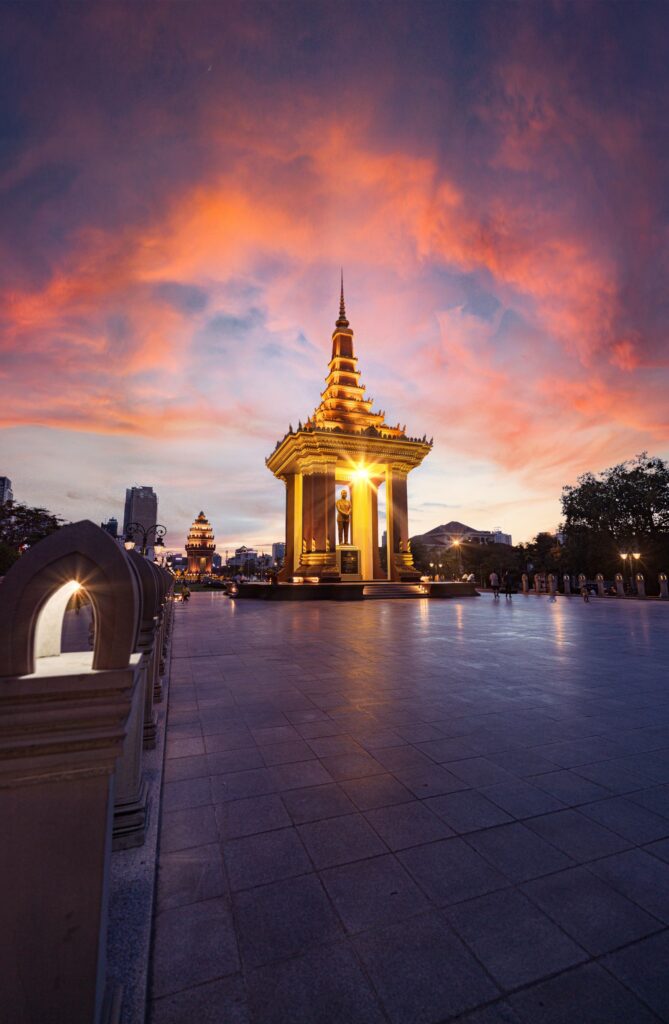 A gilded Buddhist monument in Phnom Penh under a sunset sky