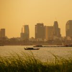 Boats on the river at sunset with the Phnom Penh skyline behind